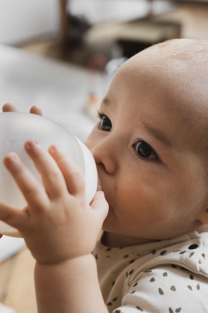Bébé qui boit seul son lait avec le biberon anti-colique Élhée