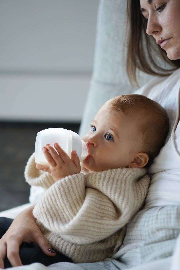 Maman qui donne le biberon en silicone Élhée blanc à son bébé